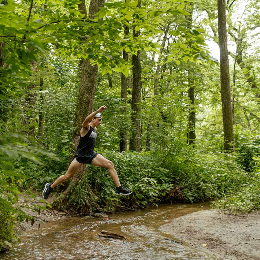 image of an individual running on a wooded trail