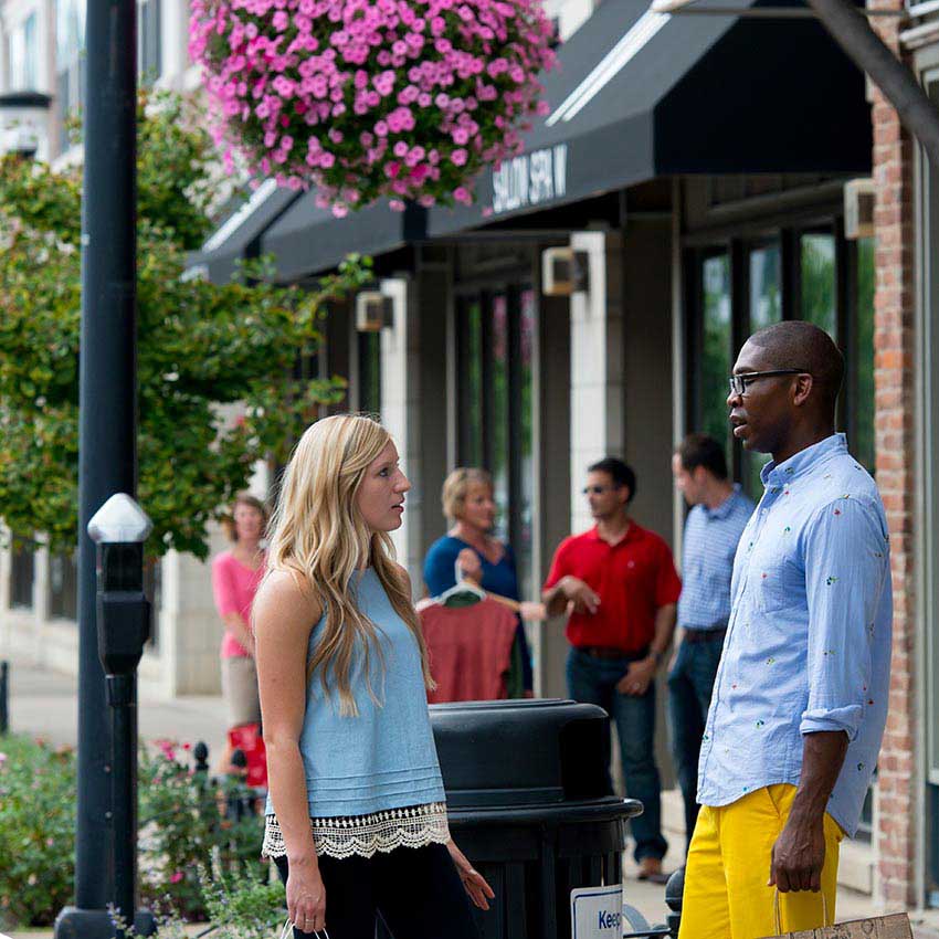 two people talking in a shopping district