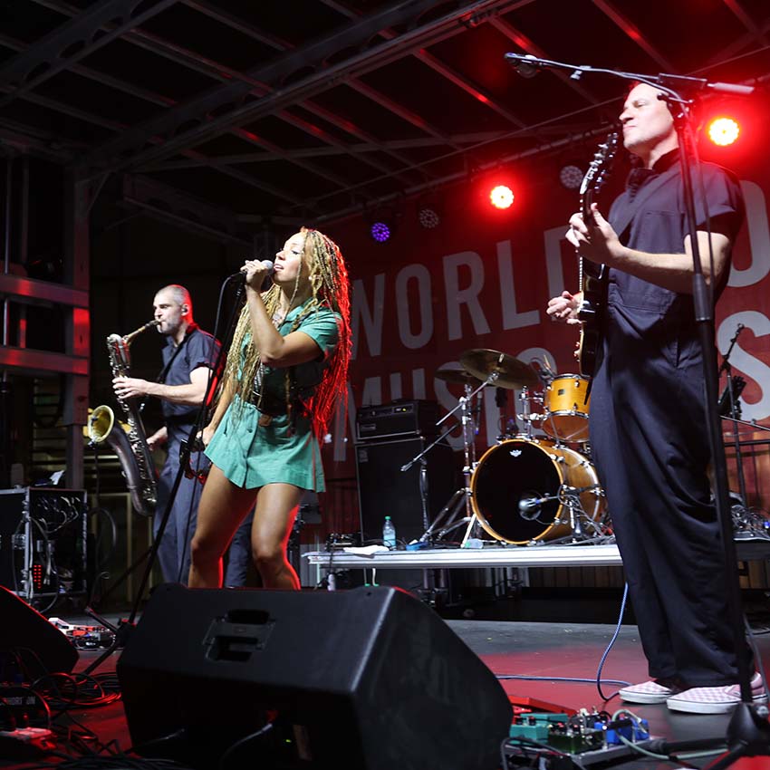 A band on stage singing and playing music.