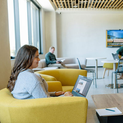 a person with a laptop sitting in a chair