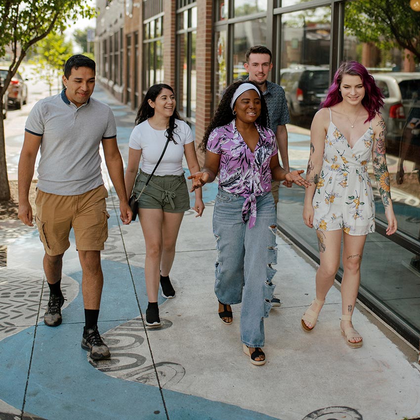 a group of individuals smiling and walking