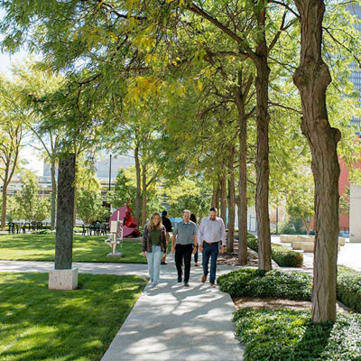 three individuals walking through a park