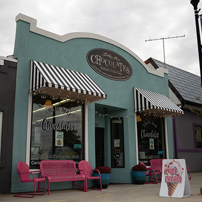 A storefront that has an ice cream sign in the front and the business name is Lillie Mae Chocolates