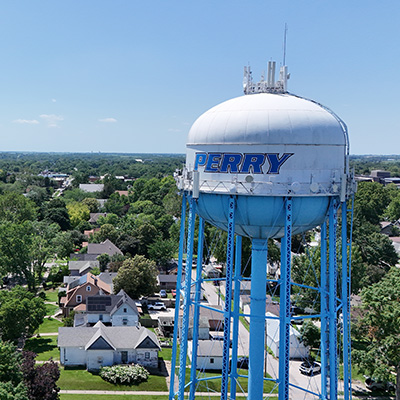 Perry A water tower that reads "Perry" and houses below it