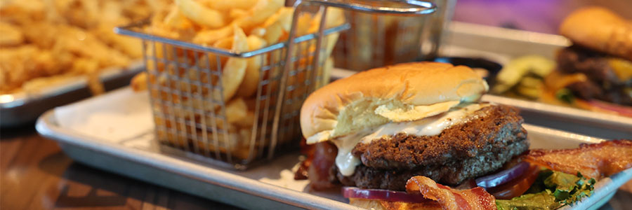 Burger Shed A burger with a variety of toppings, fries and onion rings.