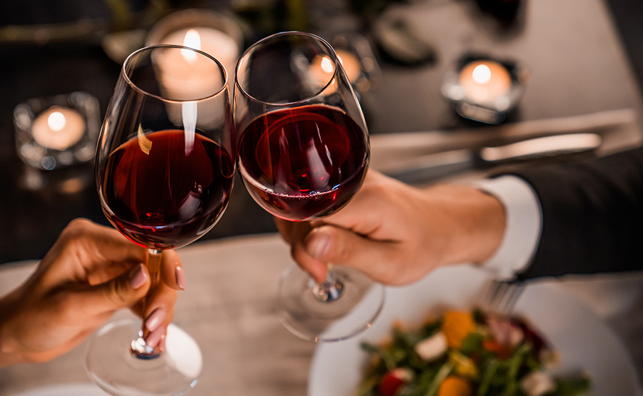 A couple toasting with a glass of wine.