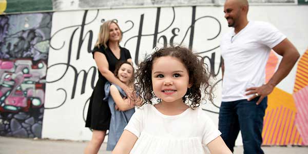 an up close shot of a young girl in front of her family. 