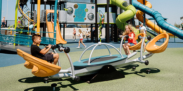 Two children playing on the playground with enjoyable expressions.
