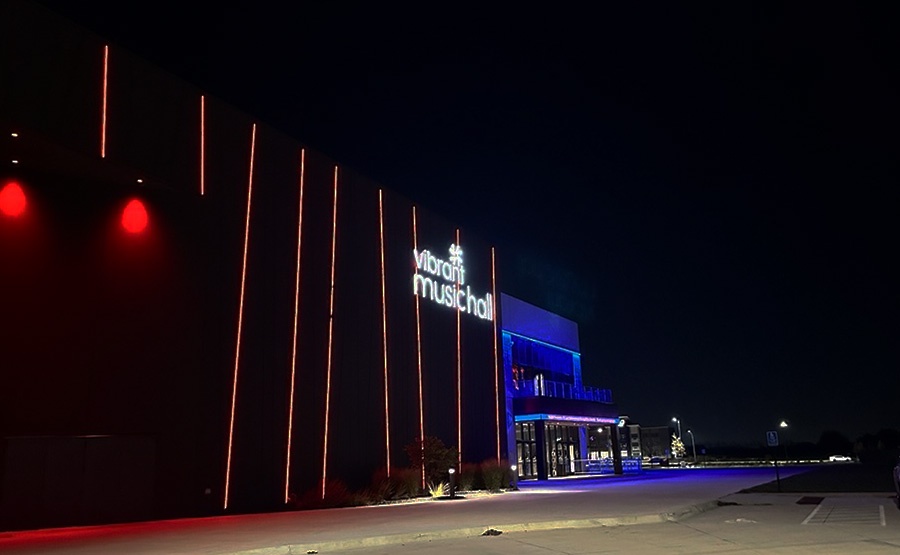 A building lit by red lights that says "Vibrant Music H
