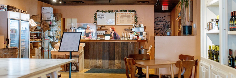 Savor the Rise Inside Savor the Rise there are pink walls, several tables for guests and olive oil displayed on the wall.