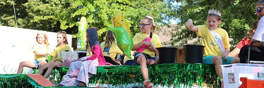 Adel Several children riding on top of a float in a parade.