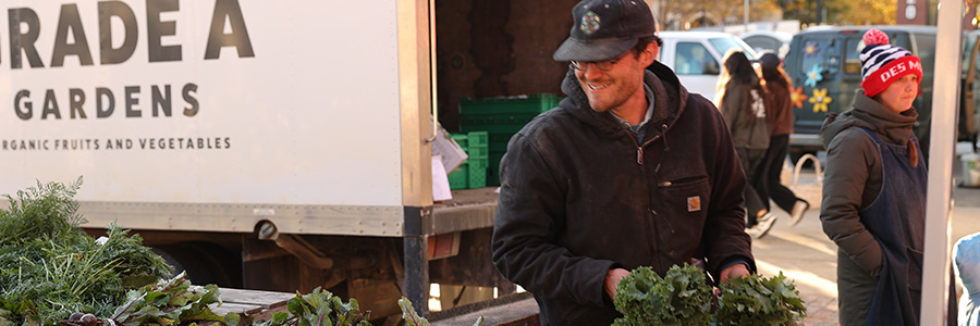 Downtown Des Moines Farmers' Market A man at the Farmers' Market handling produce.