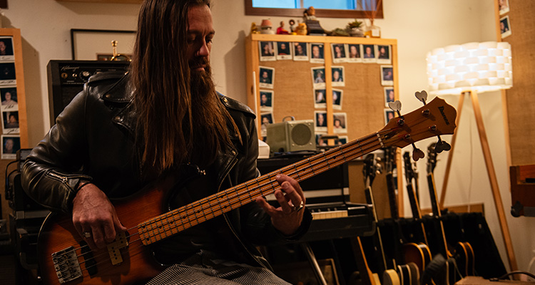 Ben Mars A man sitting and playing the bass.