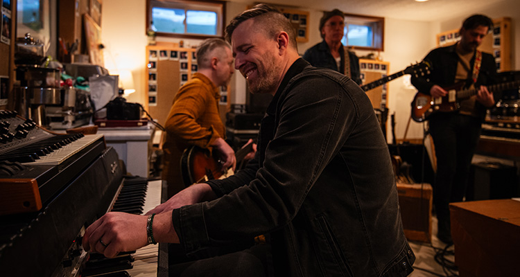 A man playing the piano and smiling