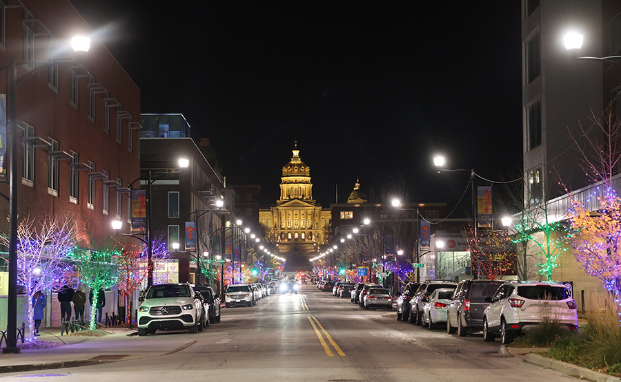 A street lit by holiday lights and colors leading up to