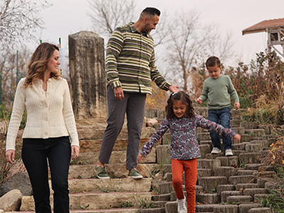 A family of four enjoying the outdoor playscape.