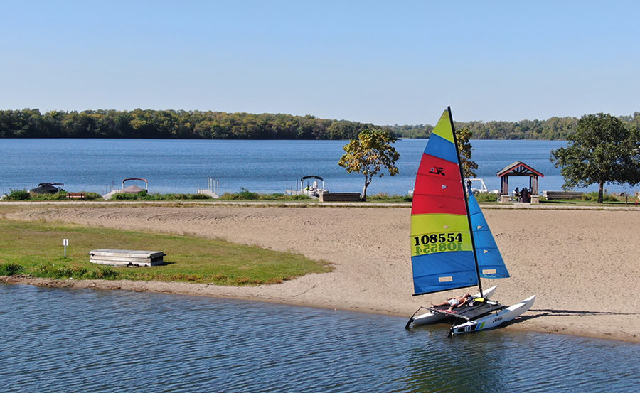 A small boat resting on the sand with a person laid out