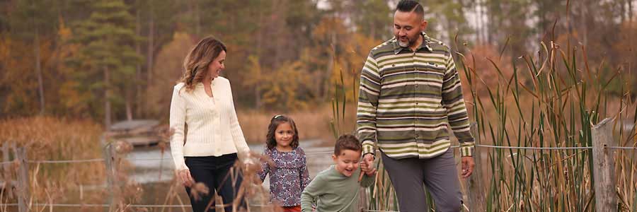 Jester Park a family of four walking on a path at a park surrounded by plants in the fall